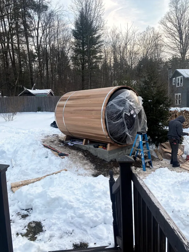 Barrel sauna being installed on its base in Woodstock