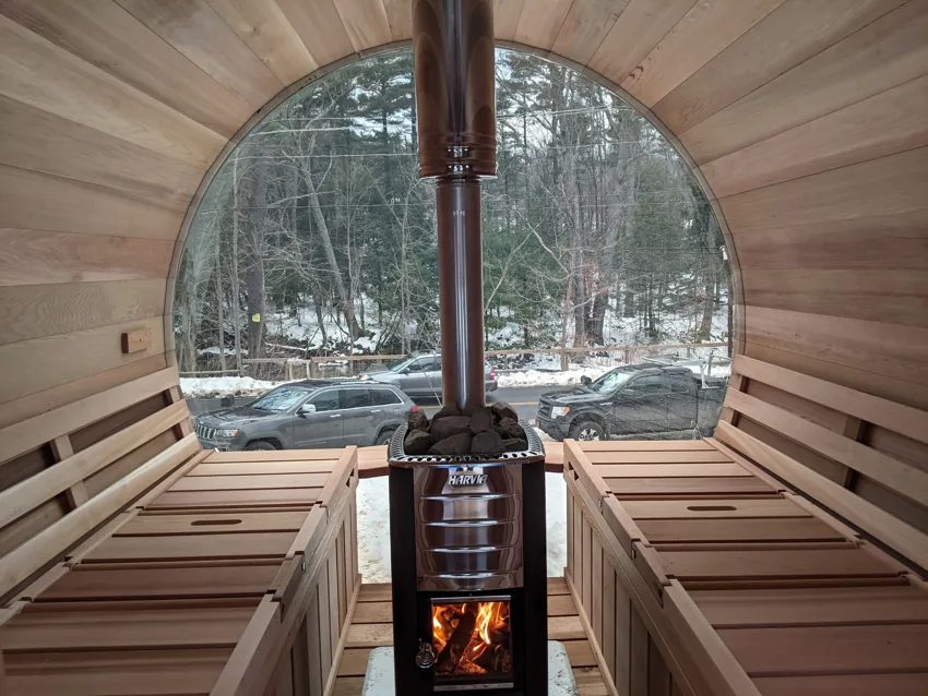 Panoramic sauna interior with a fire burning in the stove