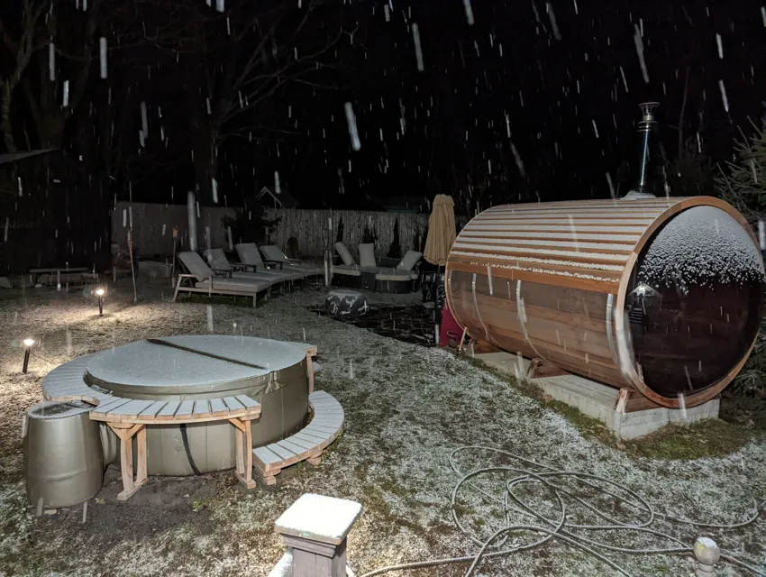 Woodstock barrel sauna during nighttime snowfall